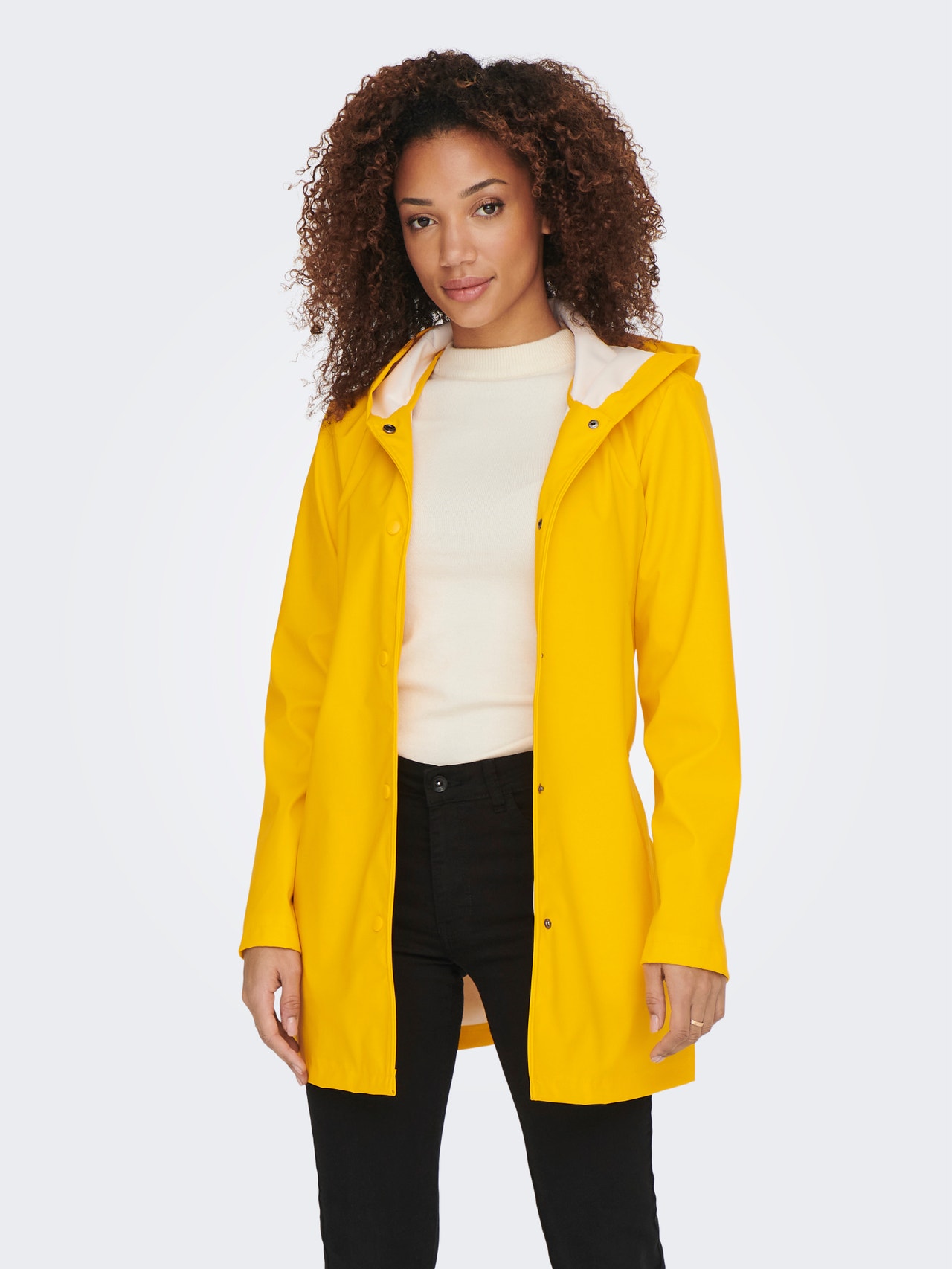 Chubasquero largo en color amarillo, con capucha, dos bolsillos y